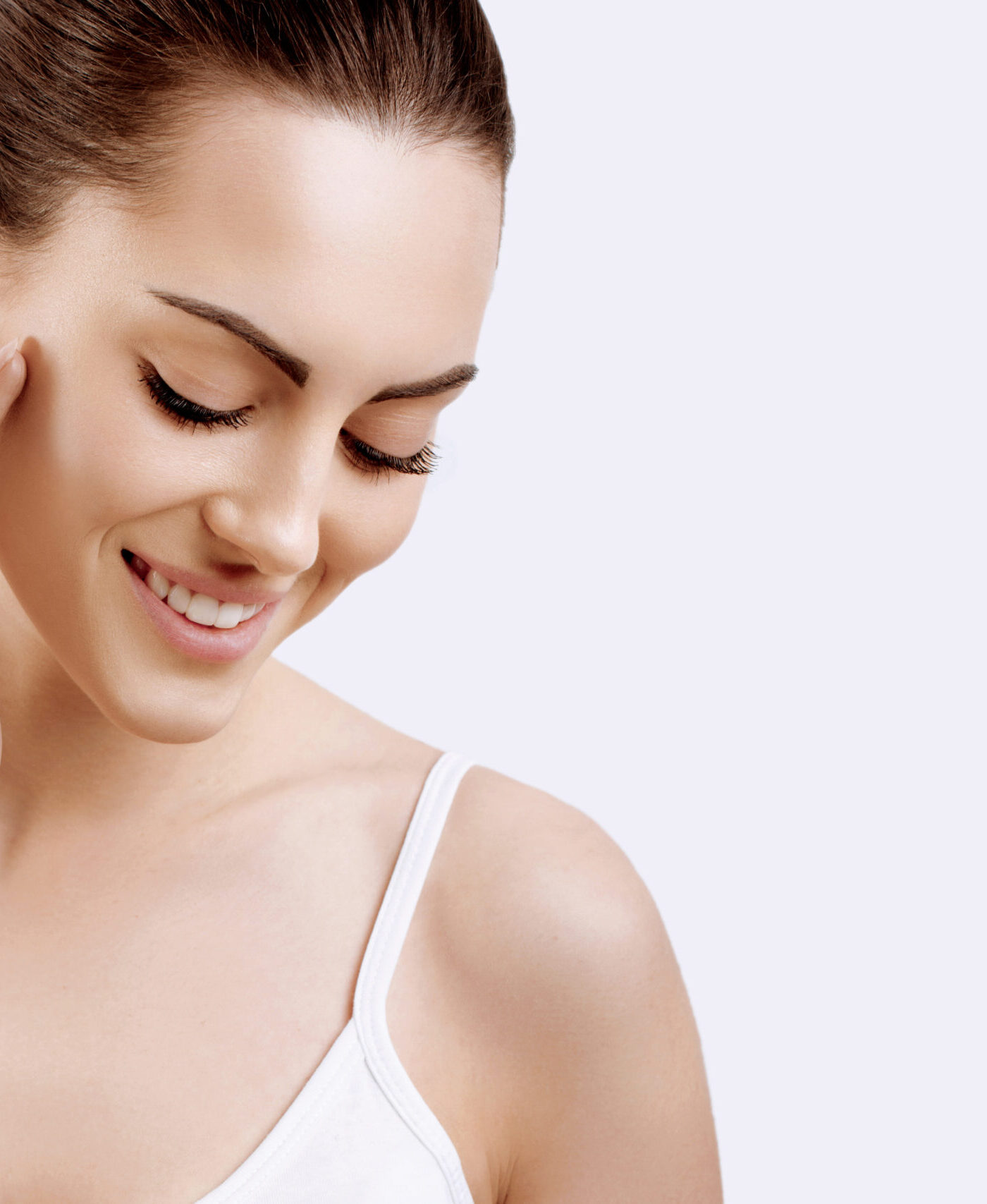 Beauty face. Smiling woman touching healthy skin portrait. Beautiful happy girl model with fresh facial skin and natural makeup on  white  background. Skin care concept